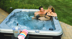 A couple sitting in a hot tub in their backyard.