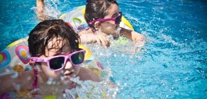Kids wearing sunglasses and swimming